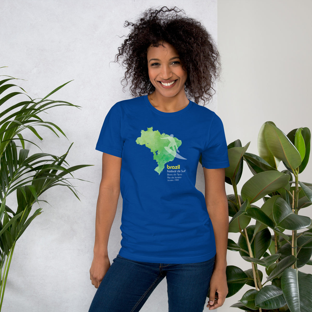 Brazil country outline with a surfer figure and "1984", vintage surf festival poster styling, printed on a SodaPop Cool t-shirt.